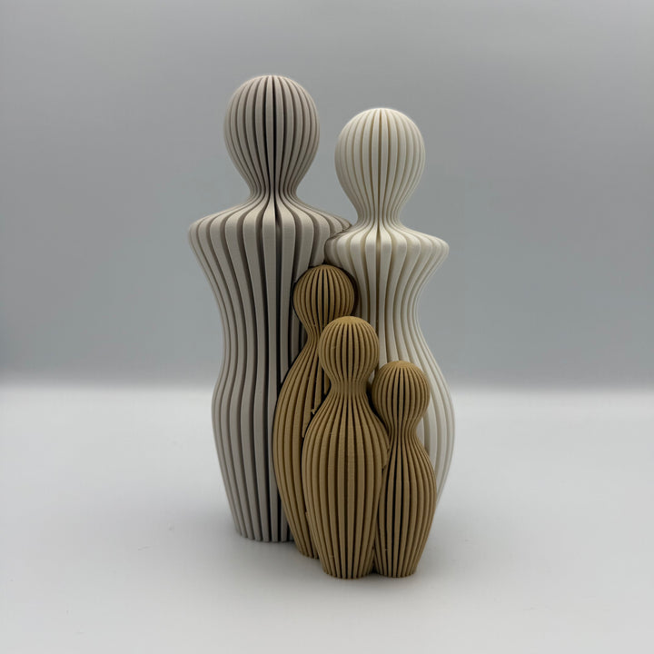 Familien, 3D-printet figur med to lyse voksne og tre gyldenbrune børn i ribbet design.
